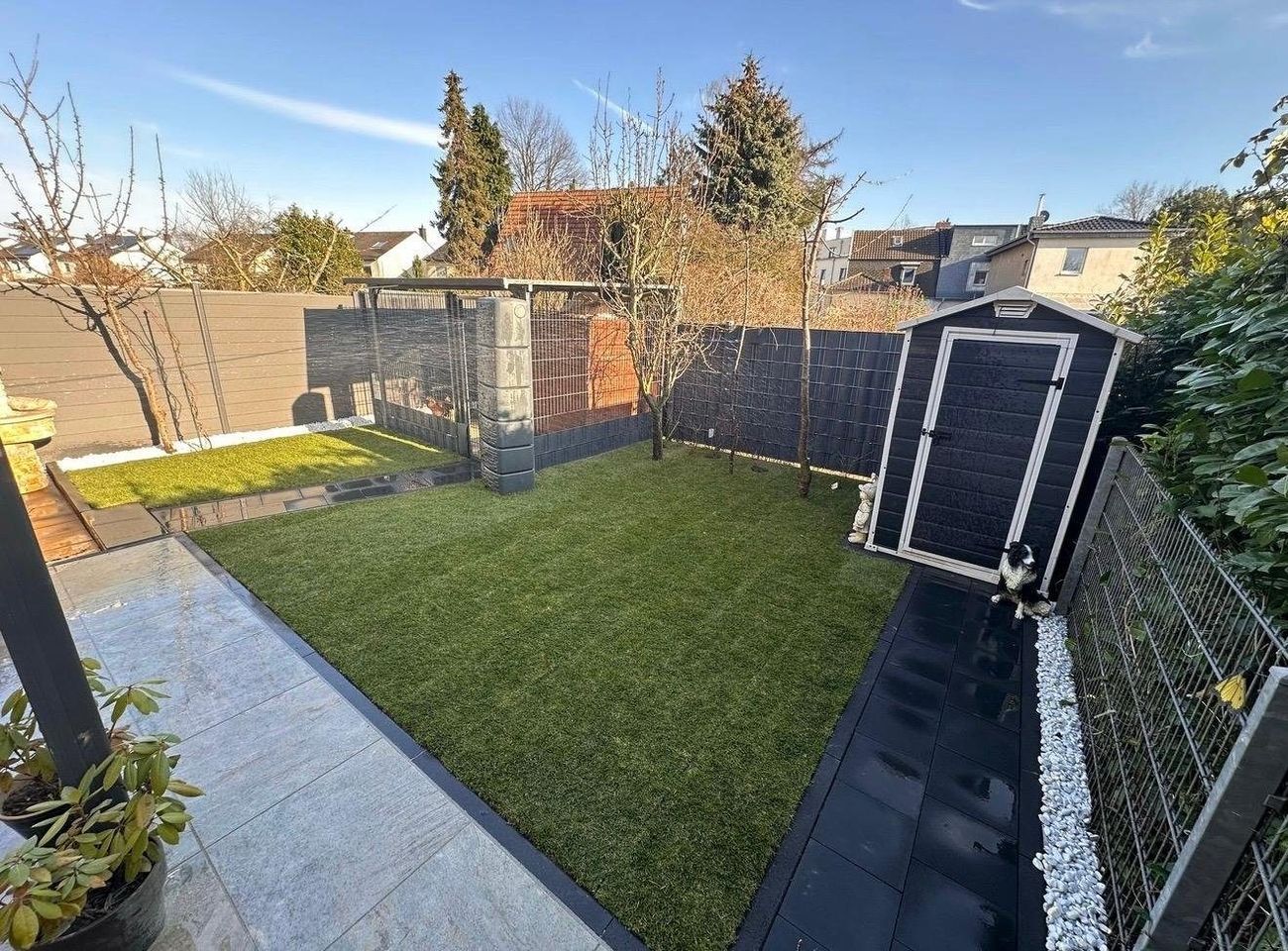 Gartenanlage mit Pflasterweg, Rasenfläche und Sichtschutz